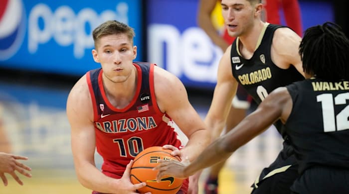 Arizona forward Azuolas Tubelis, left, drives the lane as Colorado guard Luke O'Brien, center, and forward Jabari Walker, right, defend in the first half of an NCAA college basketball game Saturday, Feb. 26, 2022, in Boulder, Colo.